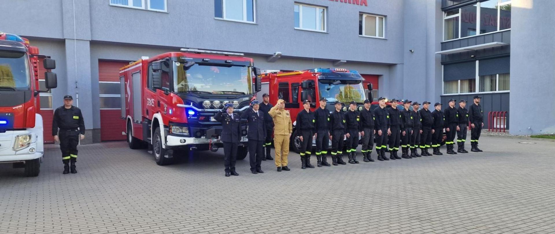 Konińscy strażacy, druhowie z OSP Konin-Chorzeń na czele z Wielkopolskim Komendantem Wojewódzkim PSP oddali hołd zmarłemu druhowie. Za nimi stoją samochody strażackie na sygnałach, 