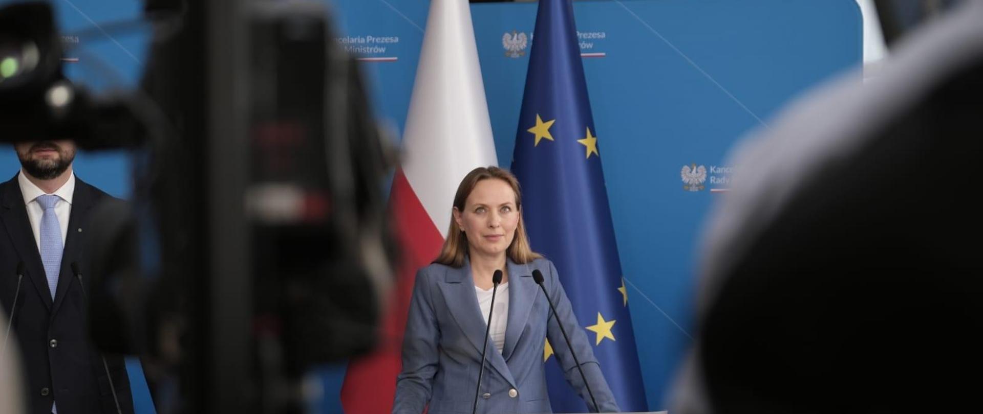 Minister Katarzyna Pełczyńska stoi przy pulpicie i mówi do mikrofonu.