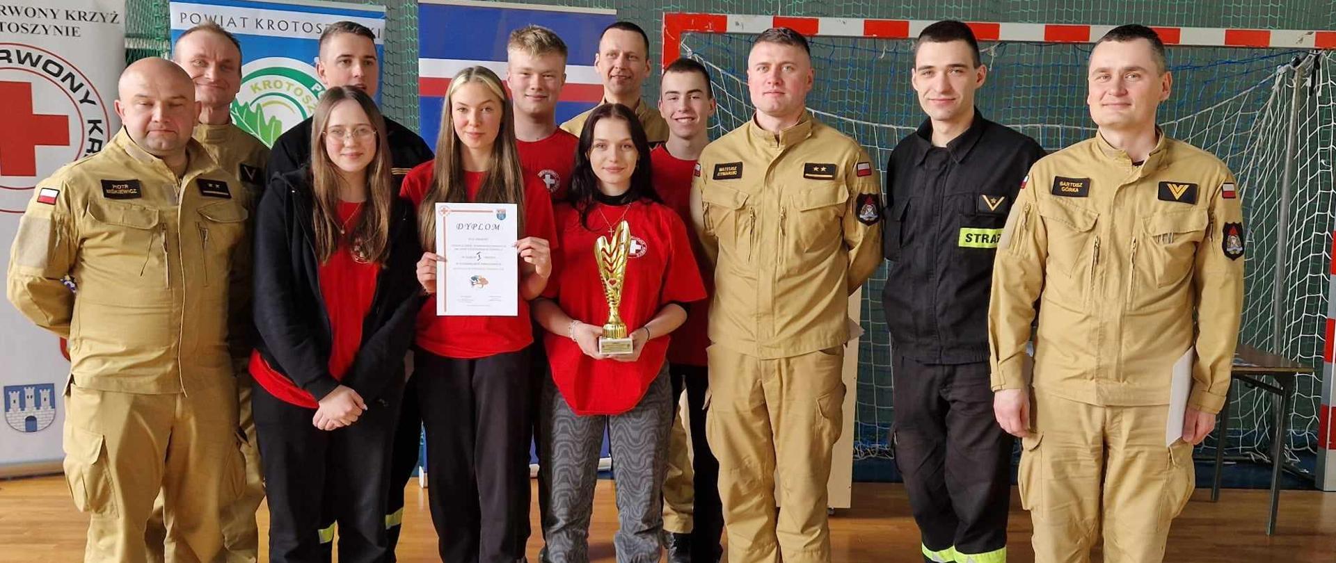 Powiatowe Mistrzostwa Pierwszej Pomocy. Na zdjęciu wygrana drużyna wraz z obsadą sędziowską, którą tworzą strażacy z komendy powiatowej. 