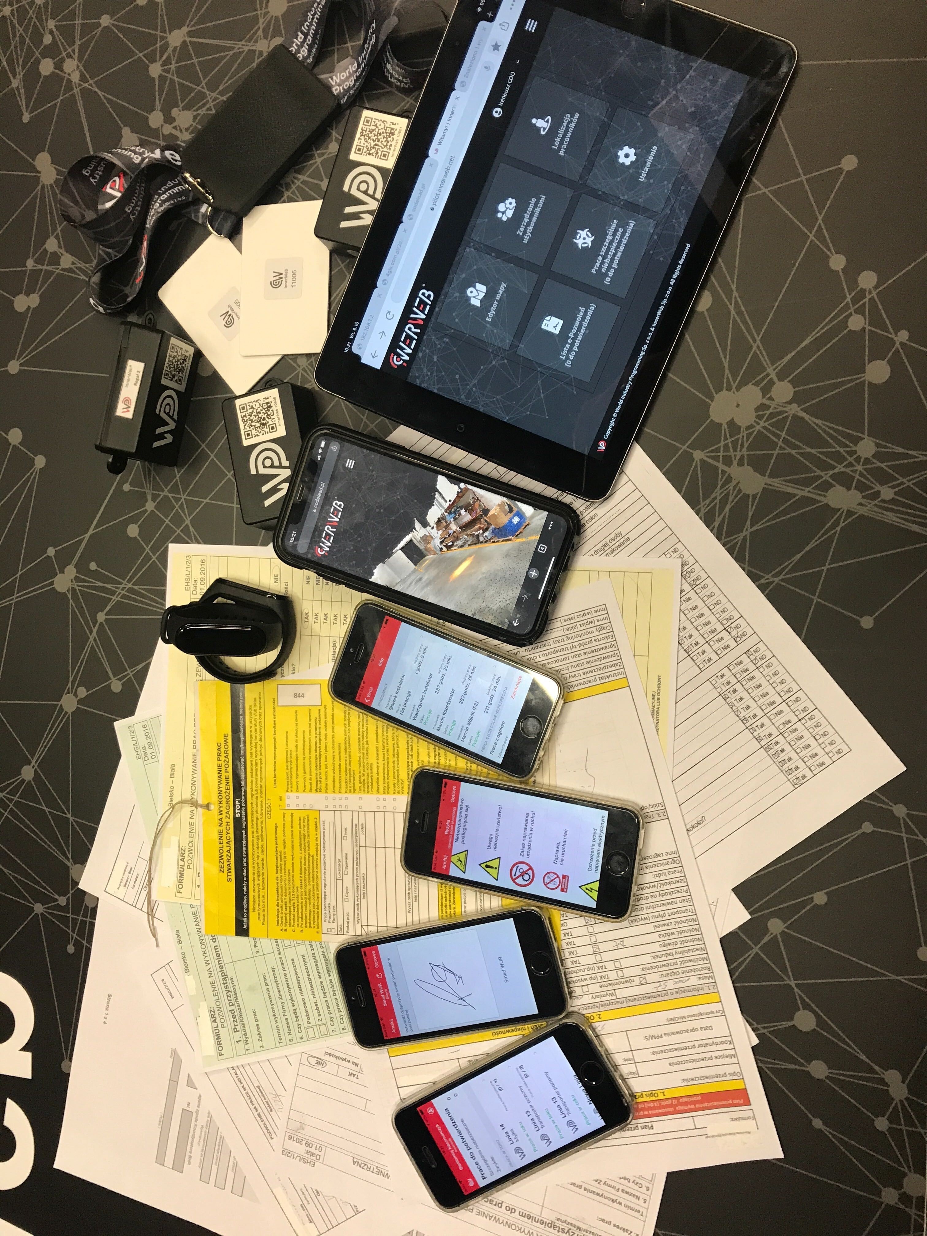 On the table with documents there are mobile devices presenting the InnerWeb application