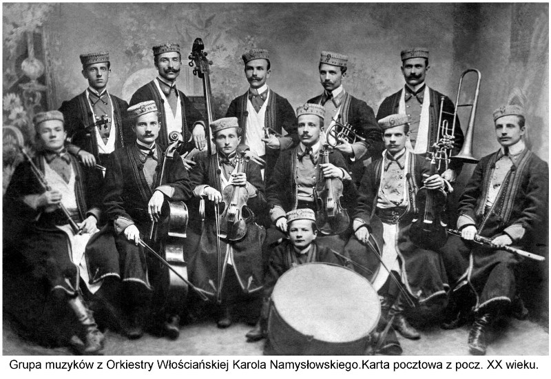 Zdjęcie przedstawia grupę muzyków Orkiestry Włościańskiej trzymających swoje instrumenty. Całość jest na szarym tle