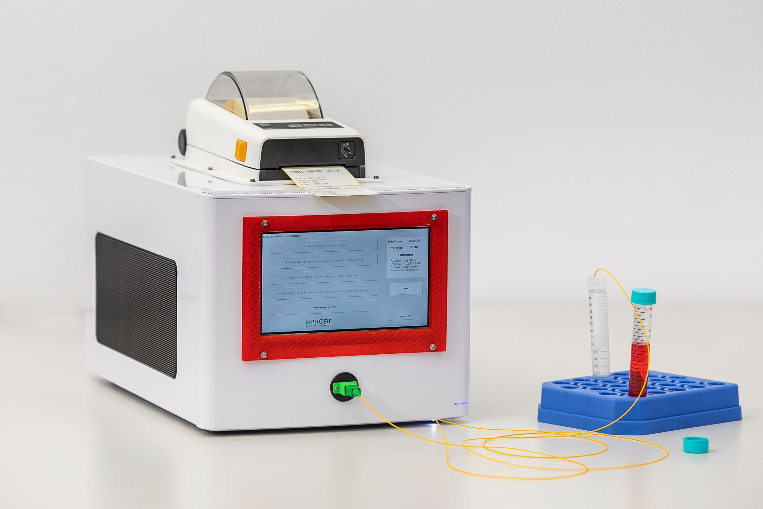 Diagnostic device in the shape of a white box in a metal case, with a screen and the possibility of printing the results. The device is connected to the test tube with thin wires.