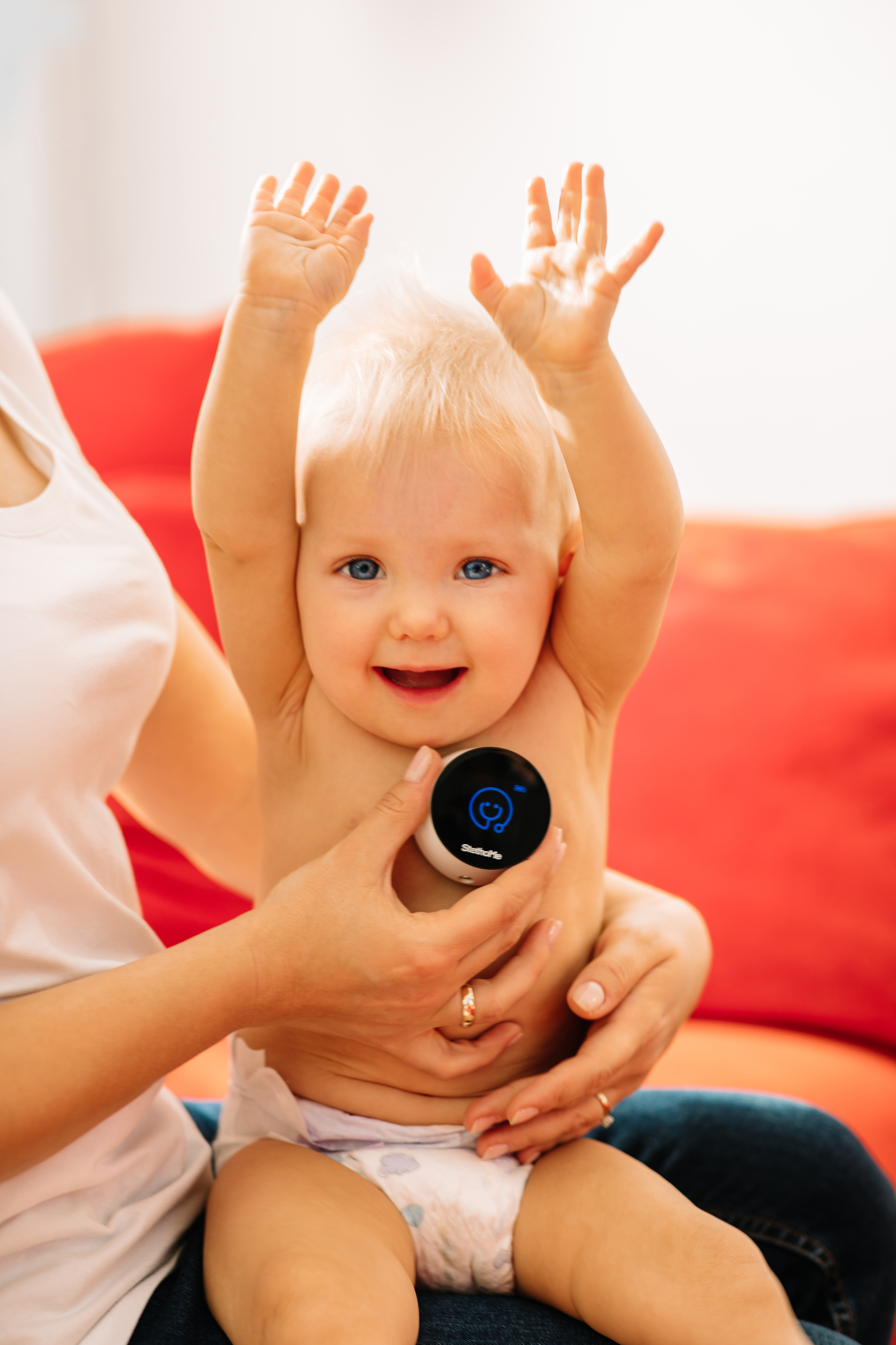 StethoMe w użyciu - urządzenie przyłożone do ciała uśmiechniętego dziecka