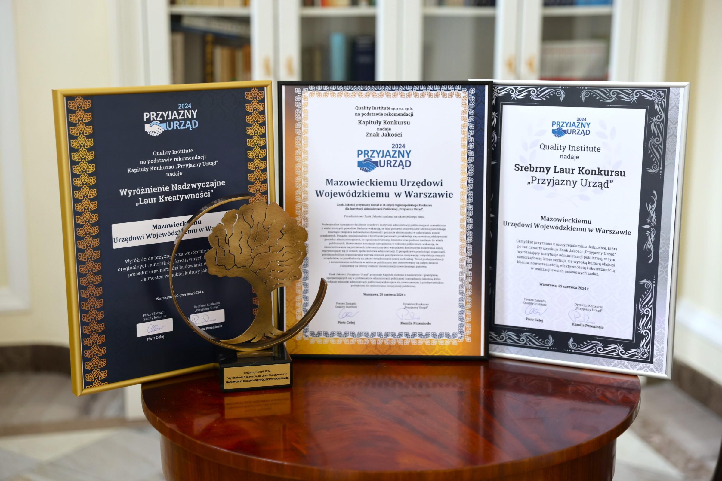 Zdjęcie przedstawia certyfikaty oprawione w ramki. Od lewej "Wyróżnienie nadzwyczajne Laur Kreatywności", po środku: "Znak Jakości Przyjazny Urząd 2024", po prawej Srebrny Laur Konkursu „Przyjazny Urząd”. 