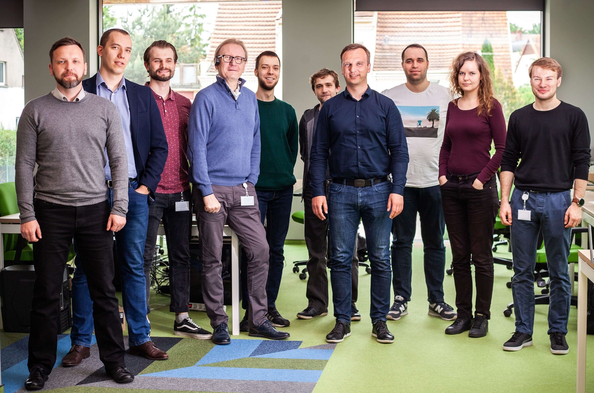 A team of ten smiling men and women standing in the office