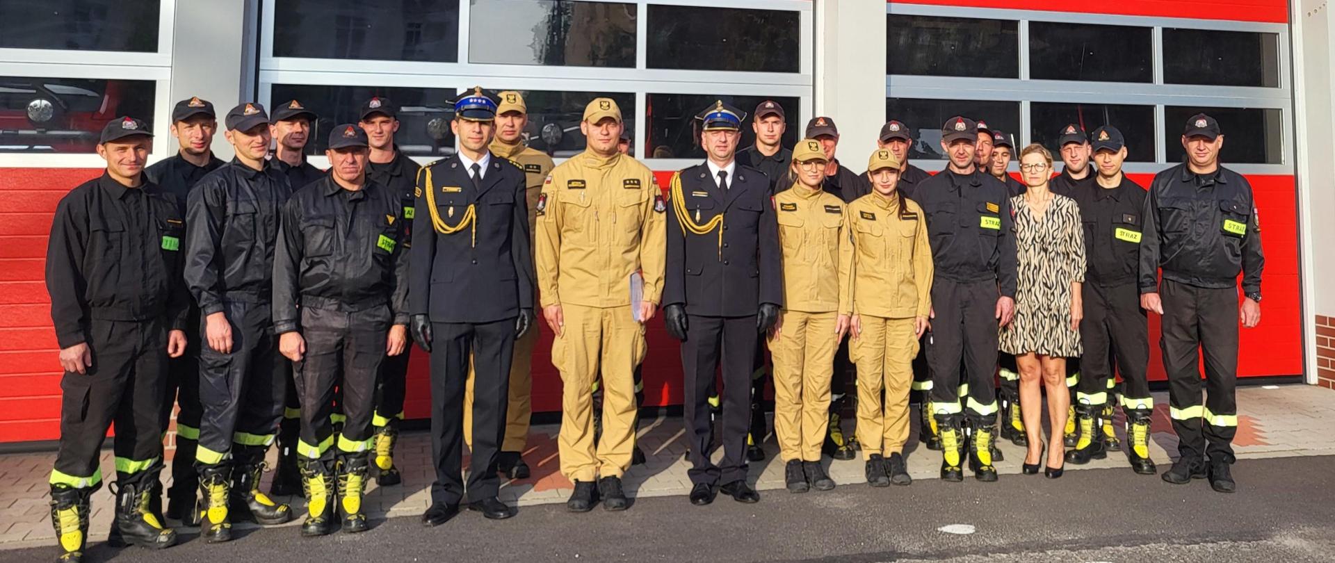 Powołanie Zastępcy Komendanta Powiatowego Państwowej Straży Pożarnej w Kościanie. Funkcjonariusze stoją w dwóch rzędach przed strażnicą, za nimi budynek Komendy.