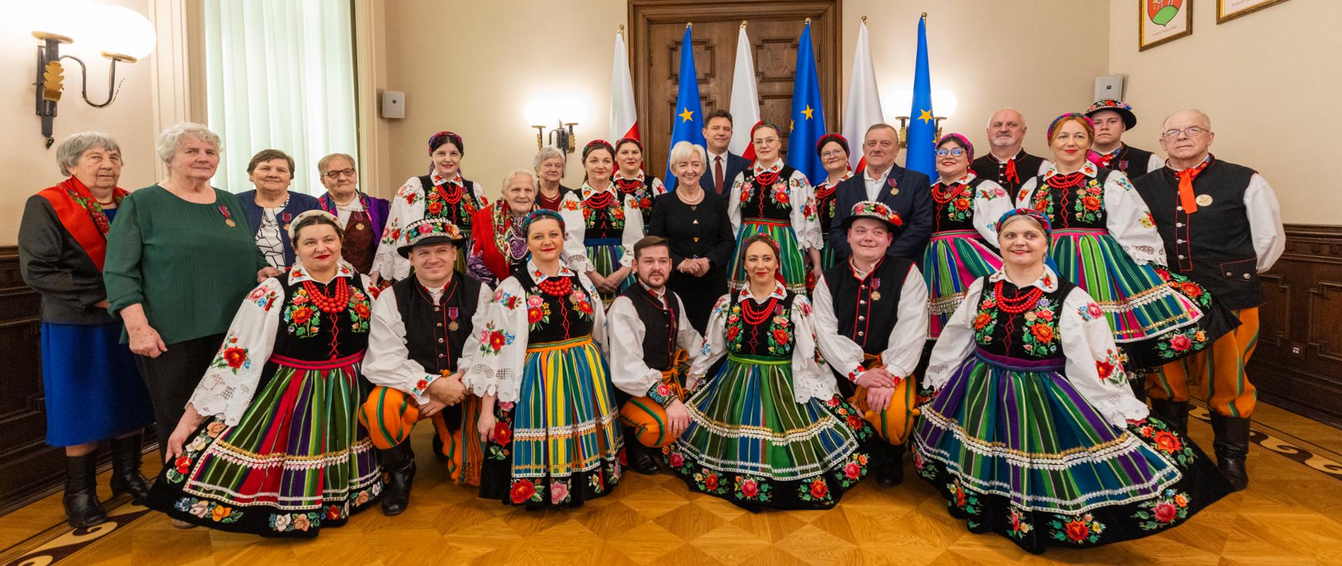 Wojewoda łódzki Dorota Ryl wspólnie z odznaczonymi przedstawicielami Zespołu Ludowego "Ziemia Słupiecka". 