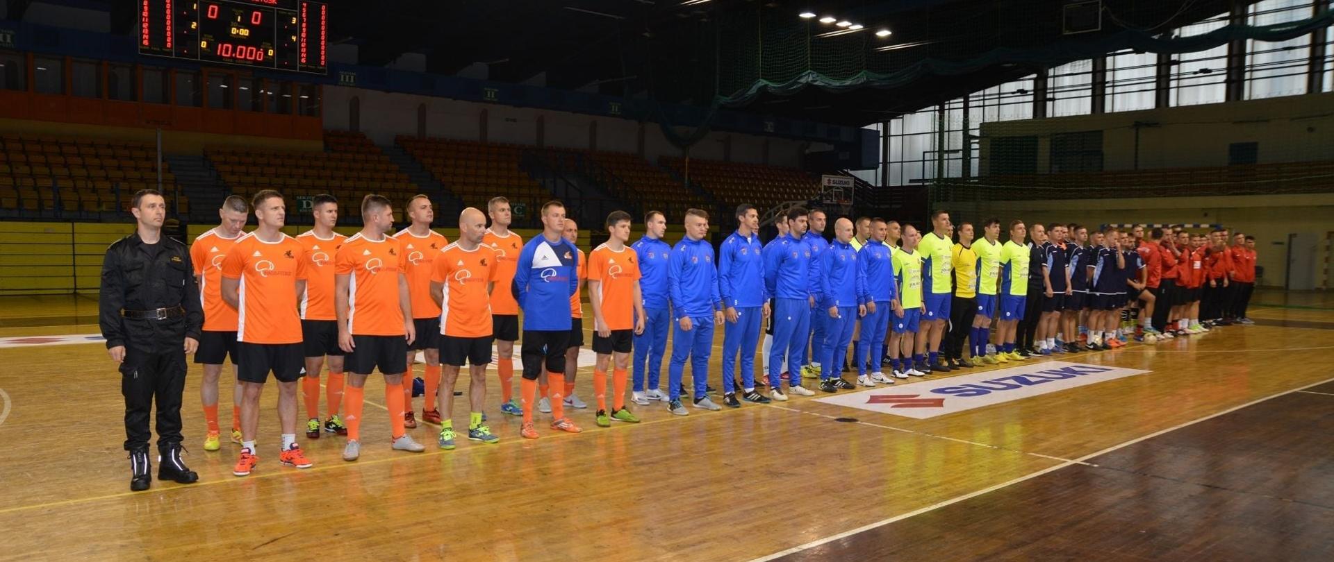 Zdjęcie przedstawia drużyny startujące w XVIII Mistrzostwach Województwa Mazowieckiego Strażaków w Halowej Piłce Nożnej. Zdjęcie wykonane na obiekcie Centrum Kultury i Sportu w Pruszkowie.