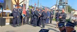 Zawady Plac przed świetlicą wiejską, na którym odbywa się uroczysty apel. Trwa wręczanie okolicznościowych statuetek gościom, przez prezesa OSP. Jako pierwszy statuetkę otrzymuje komendant powiatowy PSP. W tle poczty sztandarowe oraz zabudowania. 