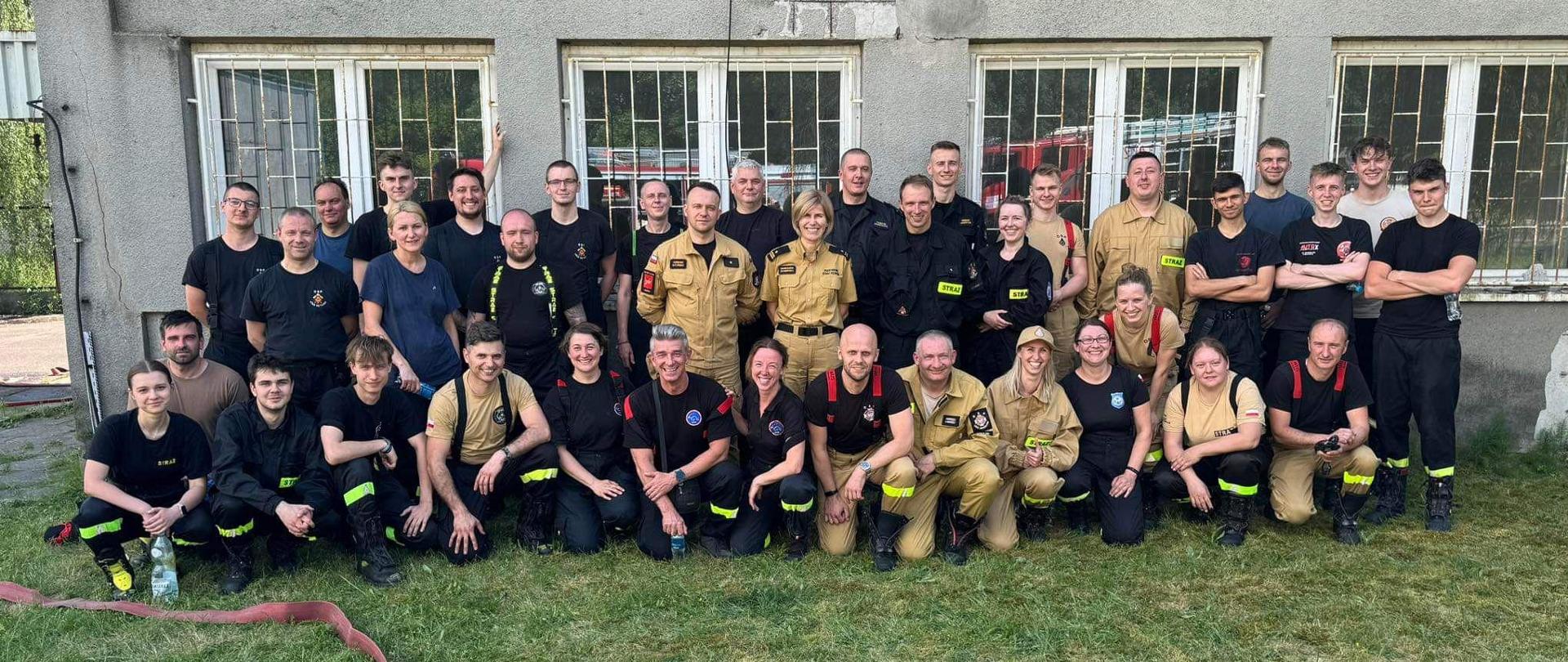 Zdjęcie grupowe na tle budynku strażaków OSP biorących udział w szkoleniu 