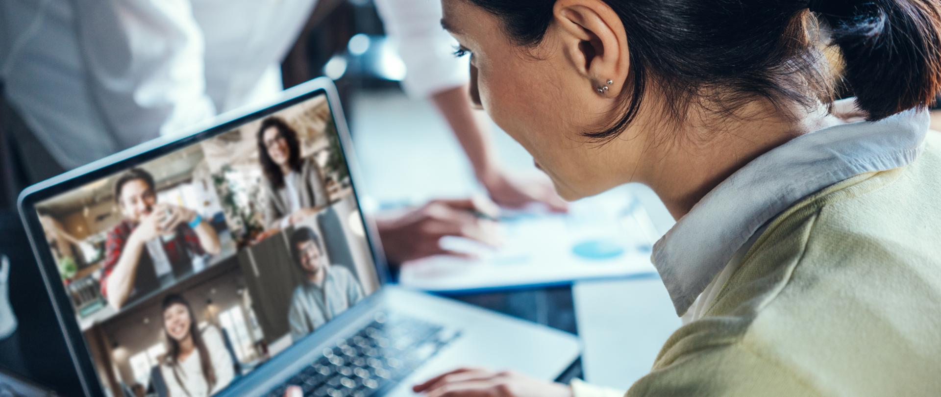 kobieta używająca laptopa do zdalnej wideokonferencji w biurze