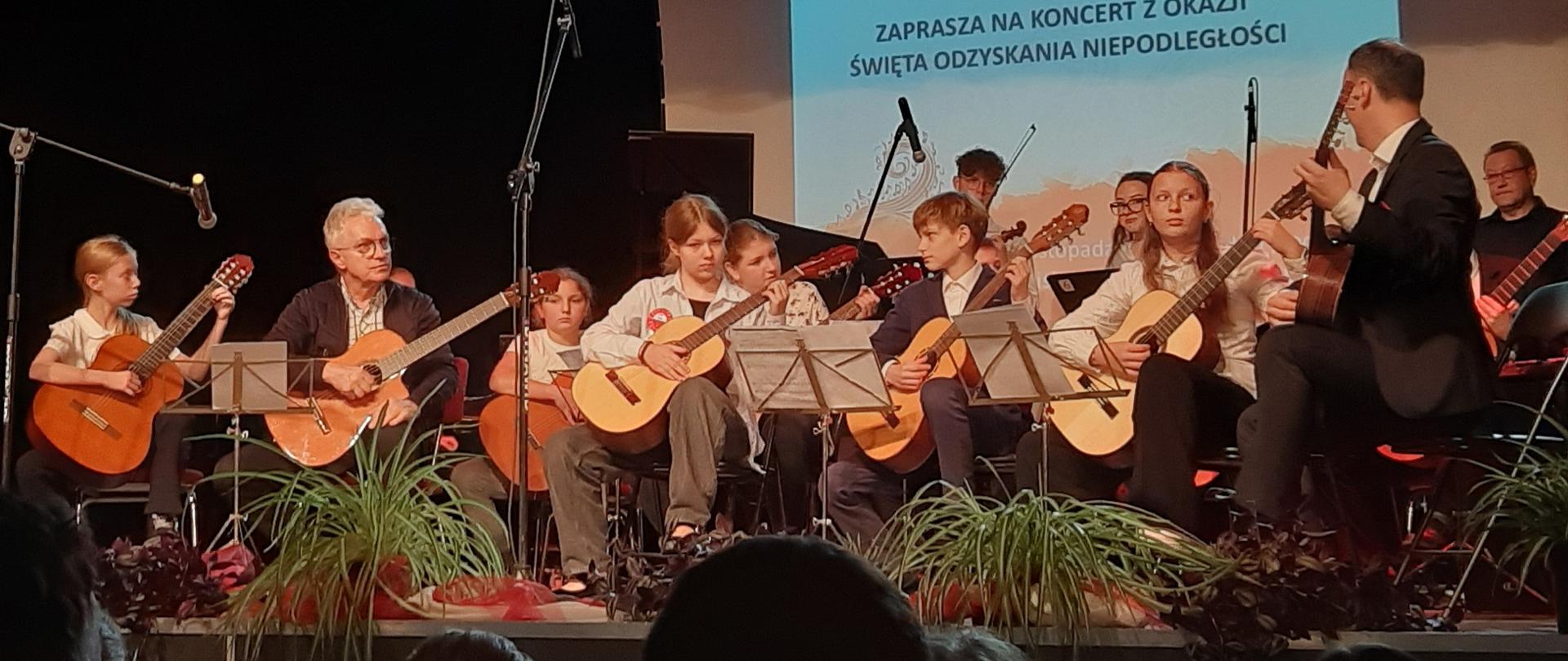 grupa gitarzystów w trakcie wspólnego występu