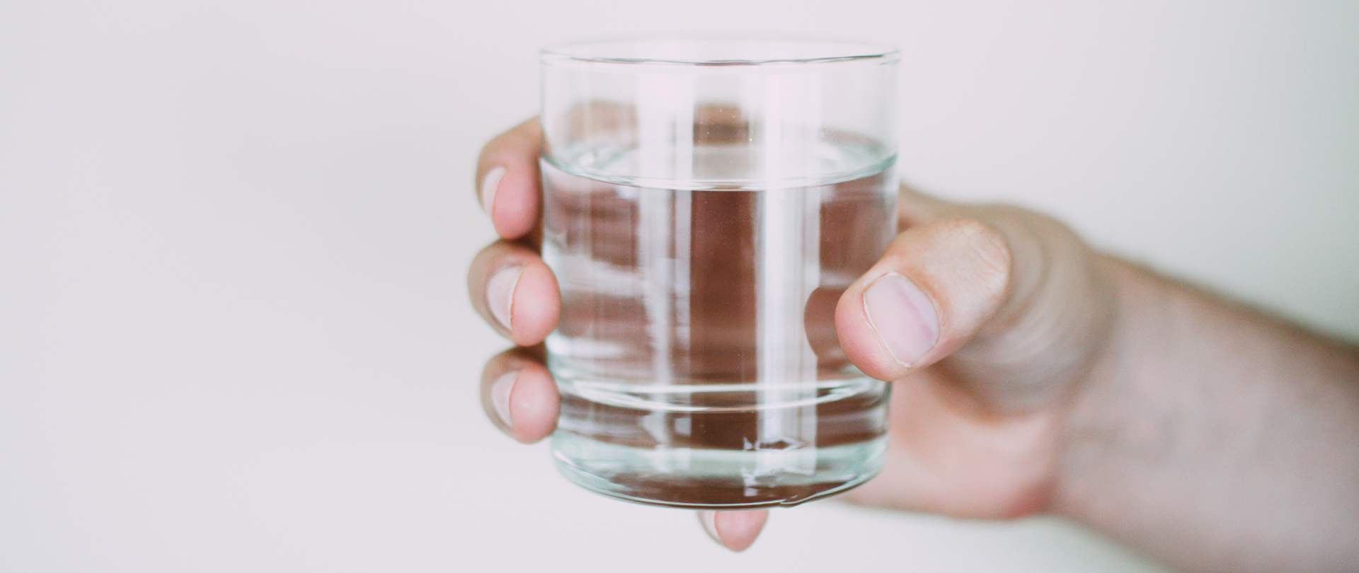 Dłoń trzymająca szklankę z wodą