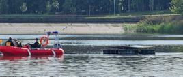 Strażacy na łodzi mierzący poziom natlenienia wody w jeziorze