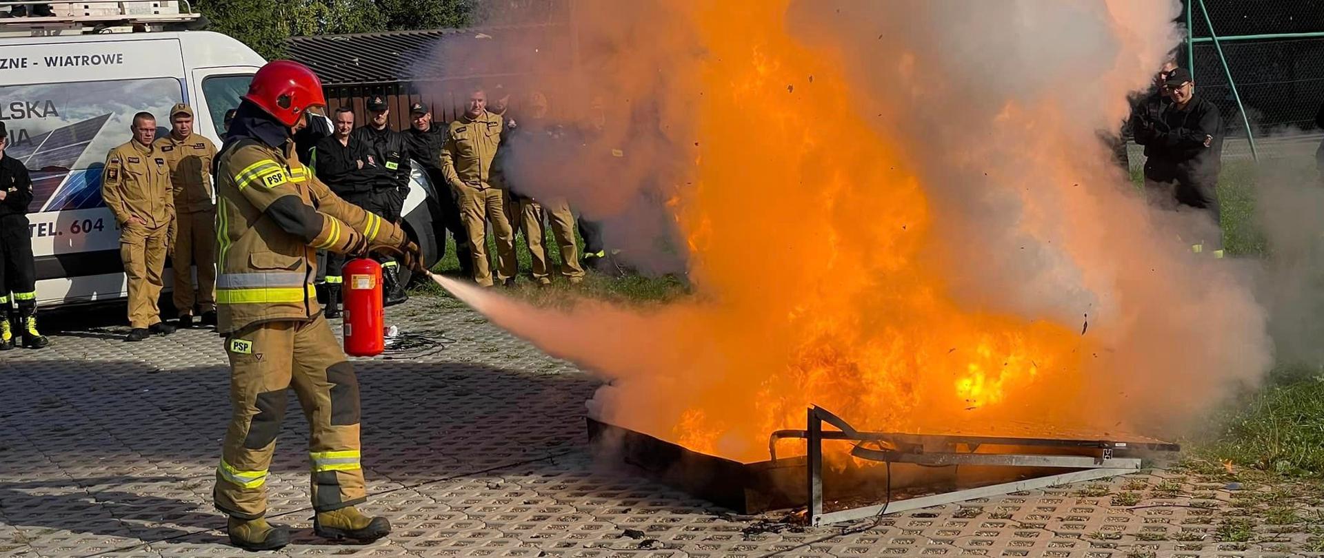 Strażak gasi gaśnicą pożar paneli fotowltaicznych