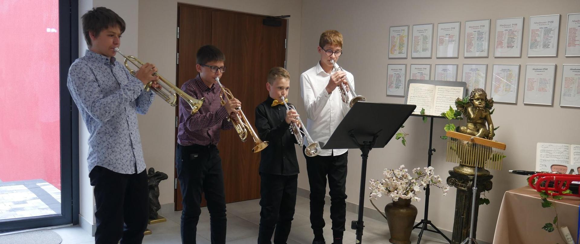 Czterech trębaczy w foyer szkoły muzycznej