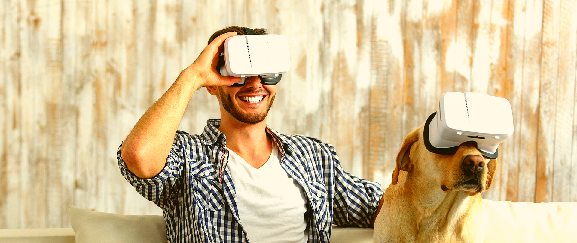Mężczyzna i pies siedzą na kanapie. Mają na sobie okulary VR