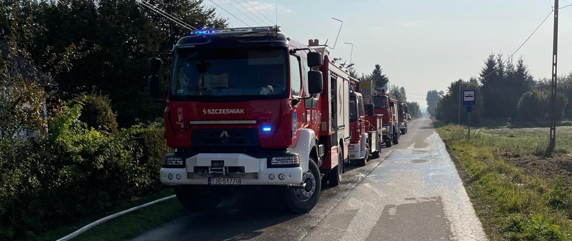 Zaparkowane na poboczu drogi pojazdy pożarnicze.