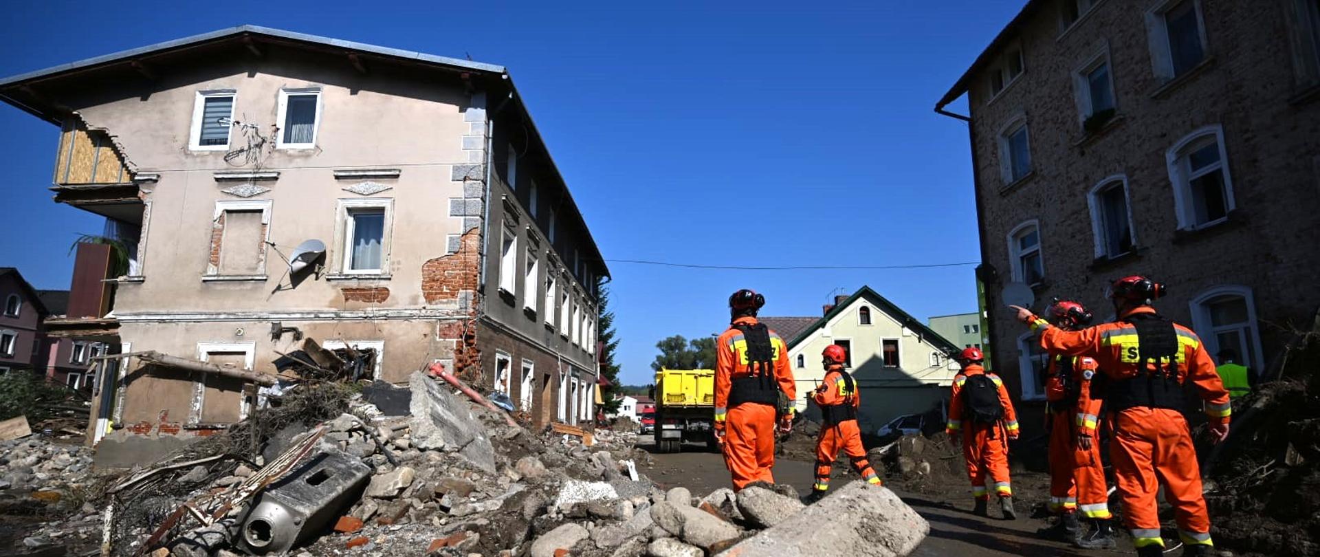 Strażacy dokonujący oględzin uszkodzonych w powodzi budynków