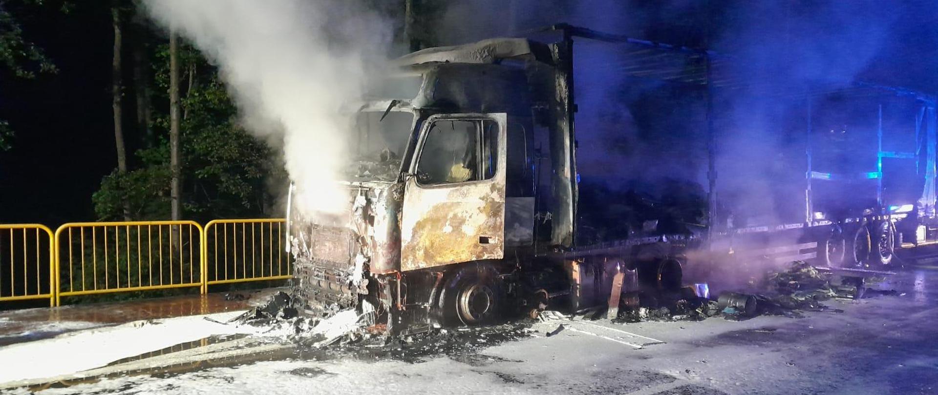 Zdjęcie przedstawia wrak spalonego samochodu ciężarowego.