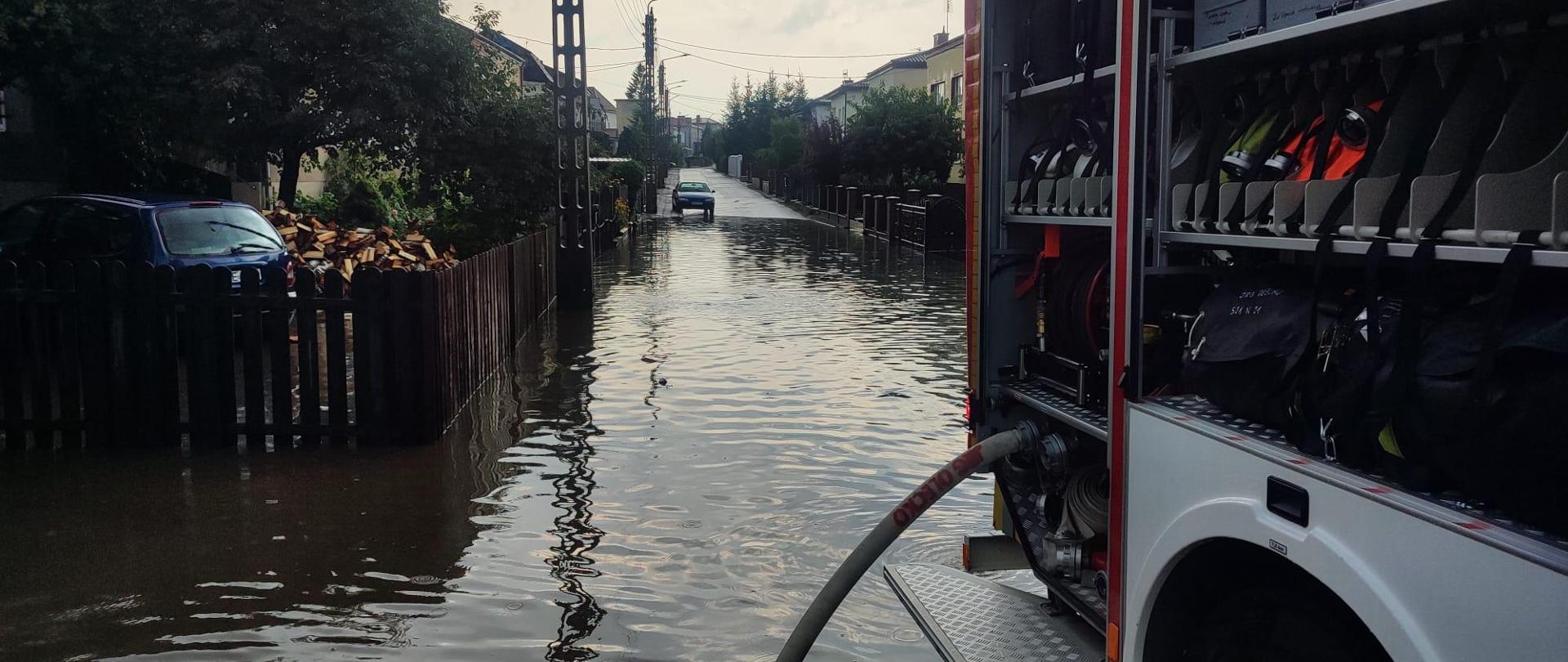 Na zdjęciu widać zalaną ulicę Mickiewicza oraz samochód ratowniczo - gaśniczy wypompowujący wodę.