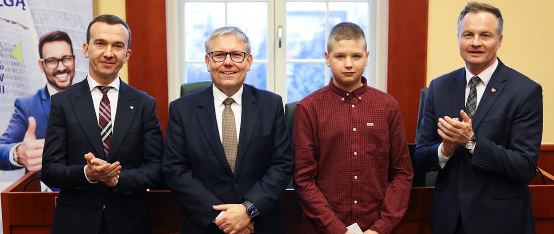 Fotografia pamiątkowa wicewojewody Mateusza Szauera wraz z laureatami podczas wręczenia nagród za konkurs "Kasa dla Asa".