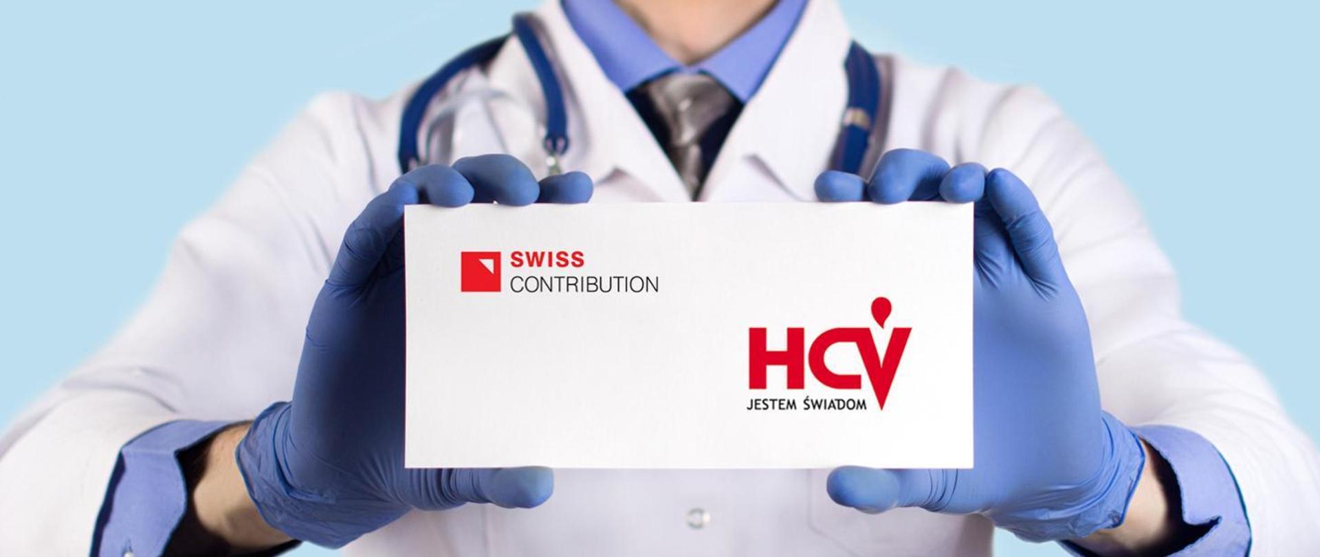 Zdjęcie nagłówkowe. Postać lekarza trzymająca białą kartkę w rozmiarze wizytówki. Na kartce czerwony napis HCV.Jestem świadom