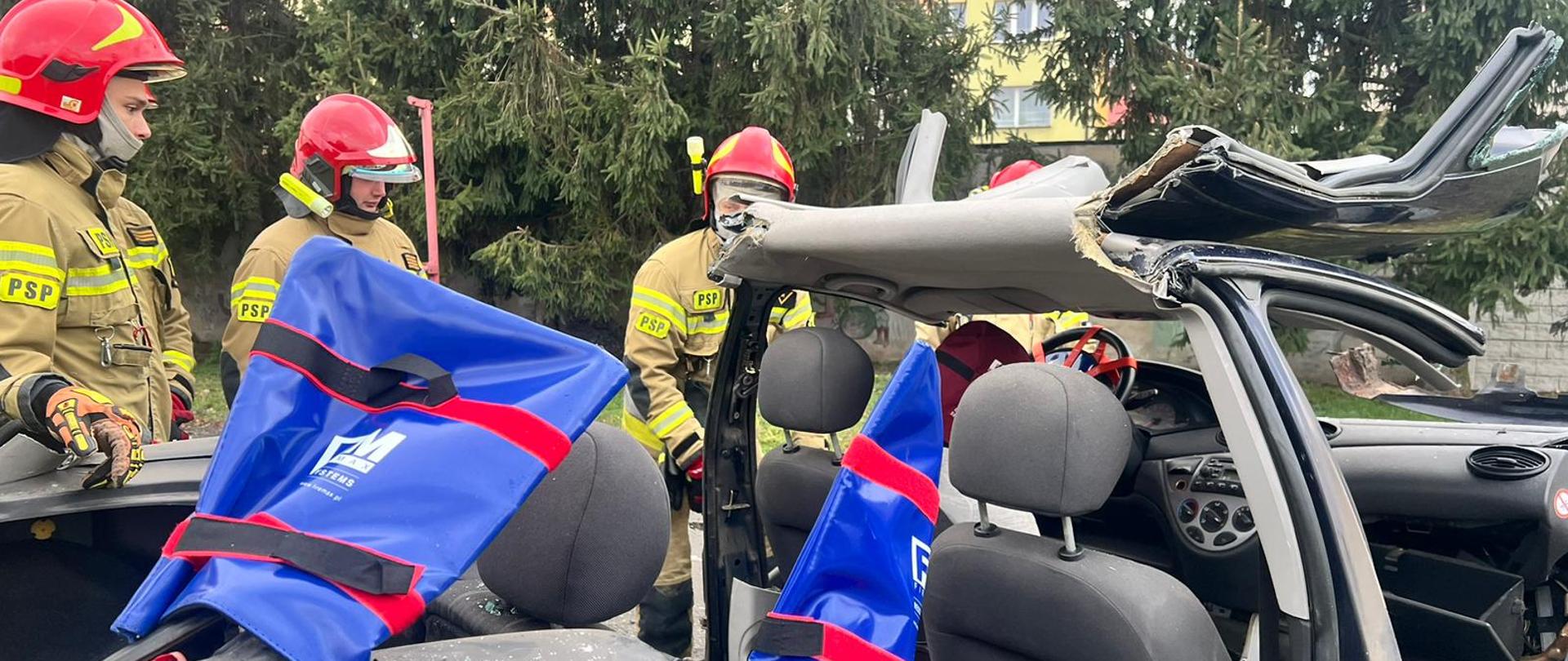 Na zdjęciu pojazd osobowy, w którym usunięto dach oraz drzwi. Trwają warsztaty z zakresu ratownictwa technicznego realizowane na placu komendy. 