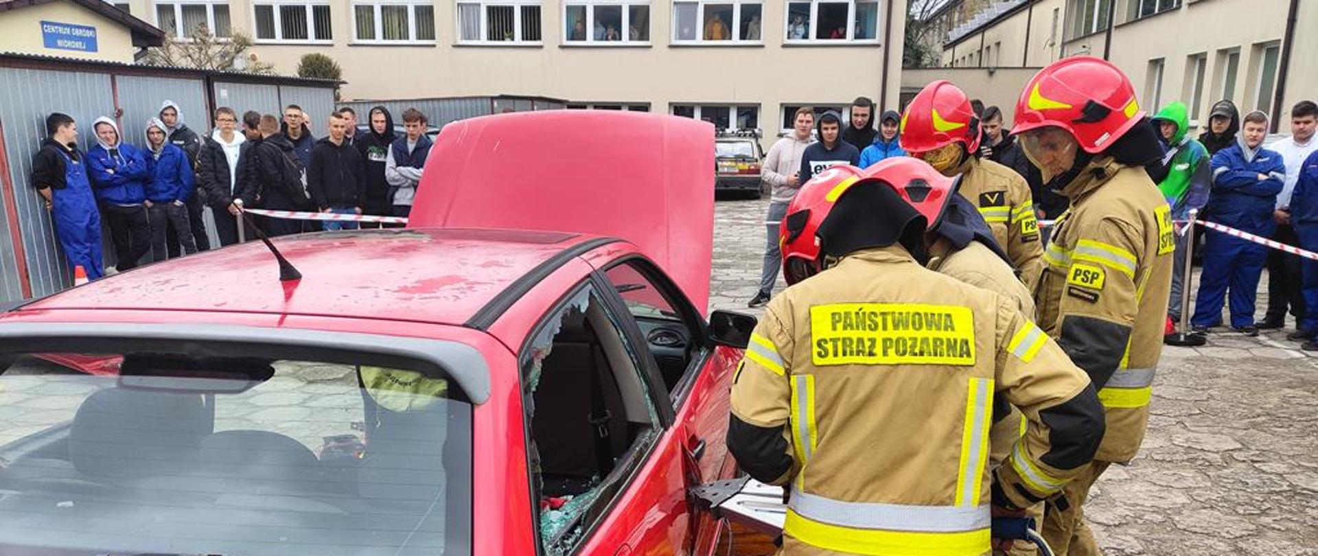 Funkcjonariusz KP PSP Staszów prowadzą działania ratownicze przy użyciu sprzętu hydraulicznego.