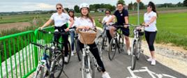Na zdjęciu widnieją pracownicy PSSE w Proszowicach, którzy jadą na rowerach na ścieżce rowerowej 