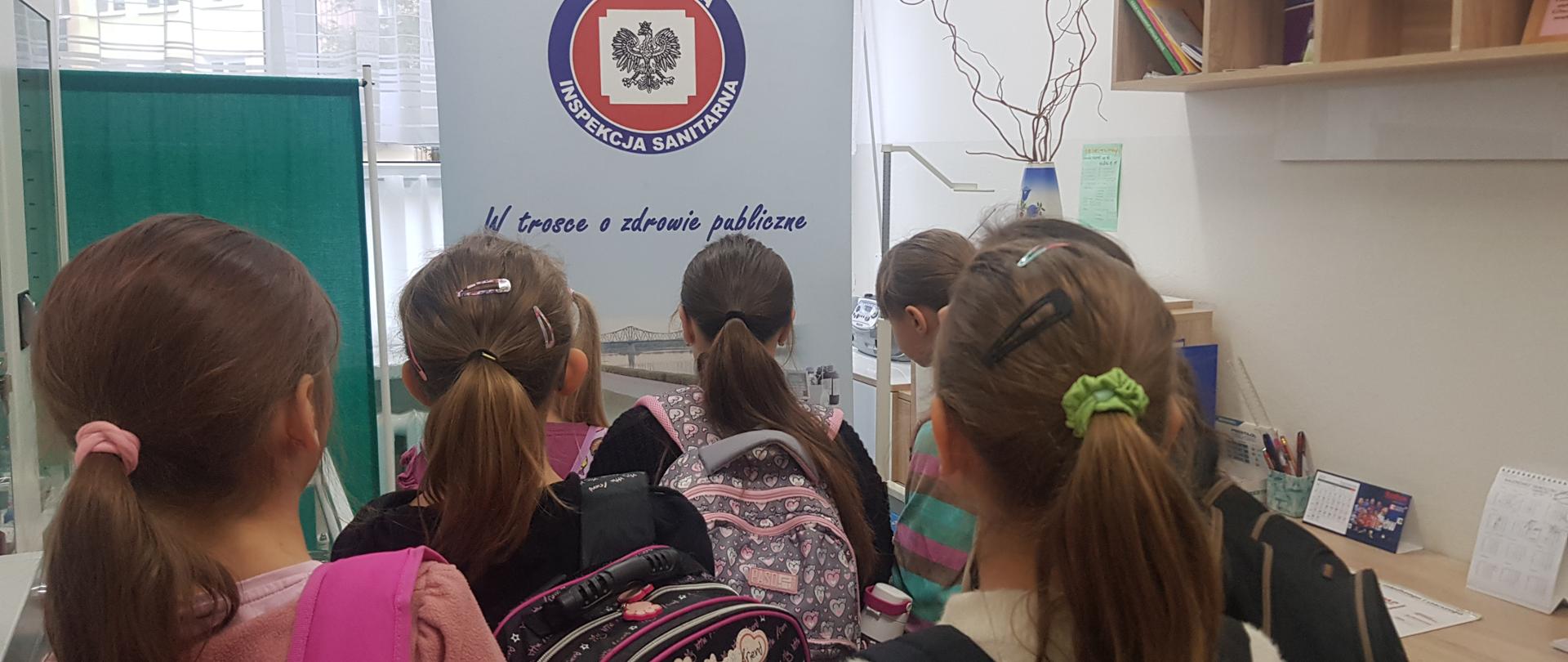 Dzieci przyglądające się banerowi PSSE We Włocławku