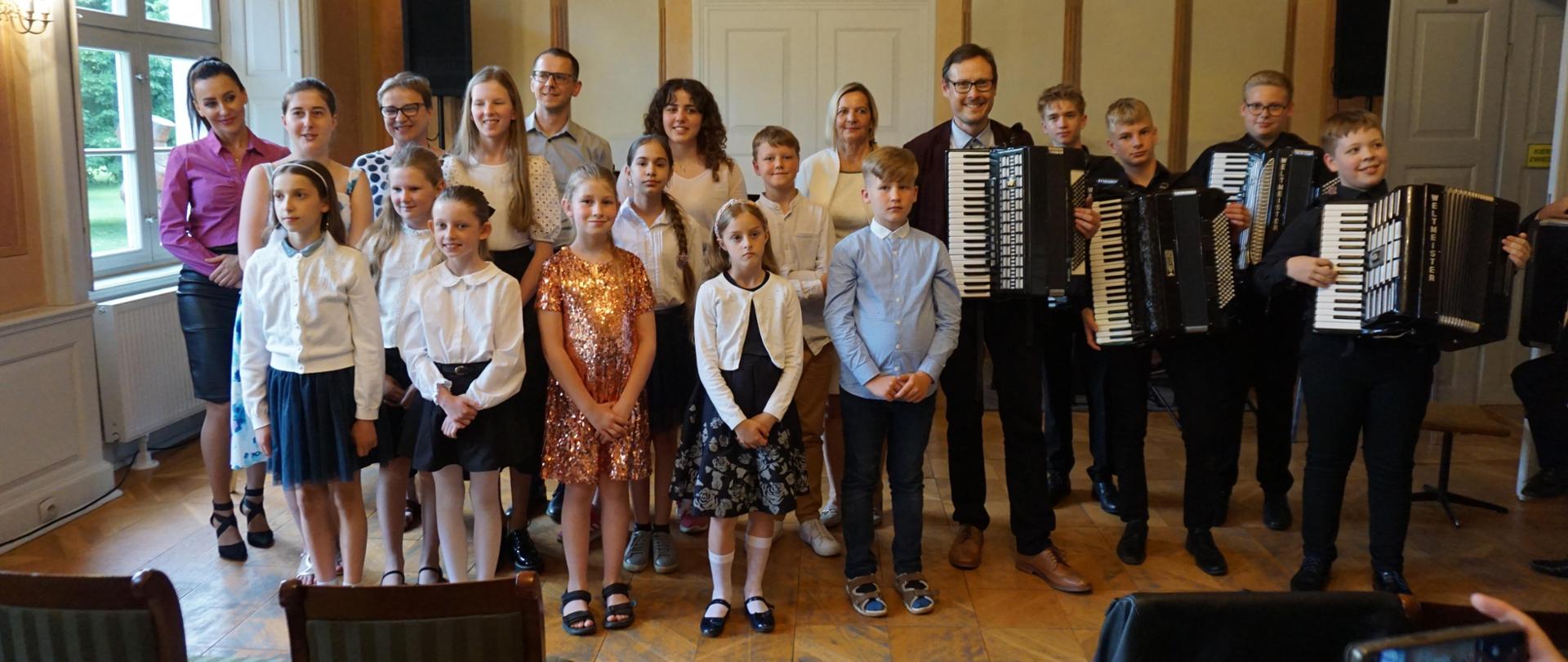 W sali balowej wejherowskiego Muzeum pozują do zdjęcia uczniowie Kursu Muzykowania oraz uczniowie i nauczyciele Państwowej Szkoły Muzycznej I st. w Wejherowie.