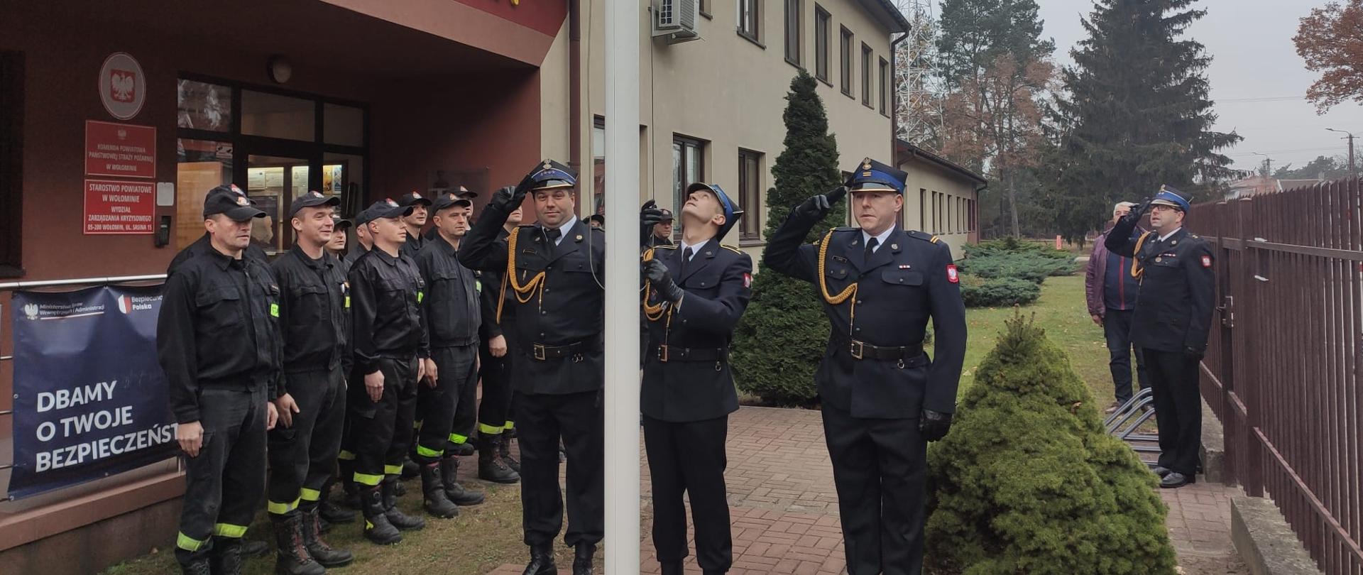 Zdjęcia przedstawiają strażaków podczas uroczystej zmiany służby z okazji uroczystości odzyskania niepodległości. Poczet flagowy w umundurowaniu wyjściowym, pozostali w umundurowaniu koszarowym.