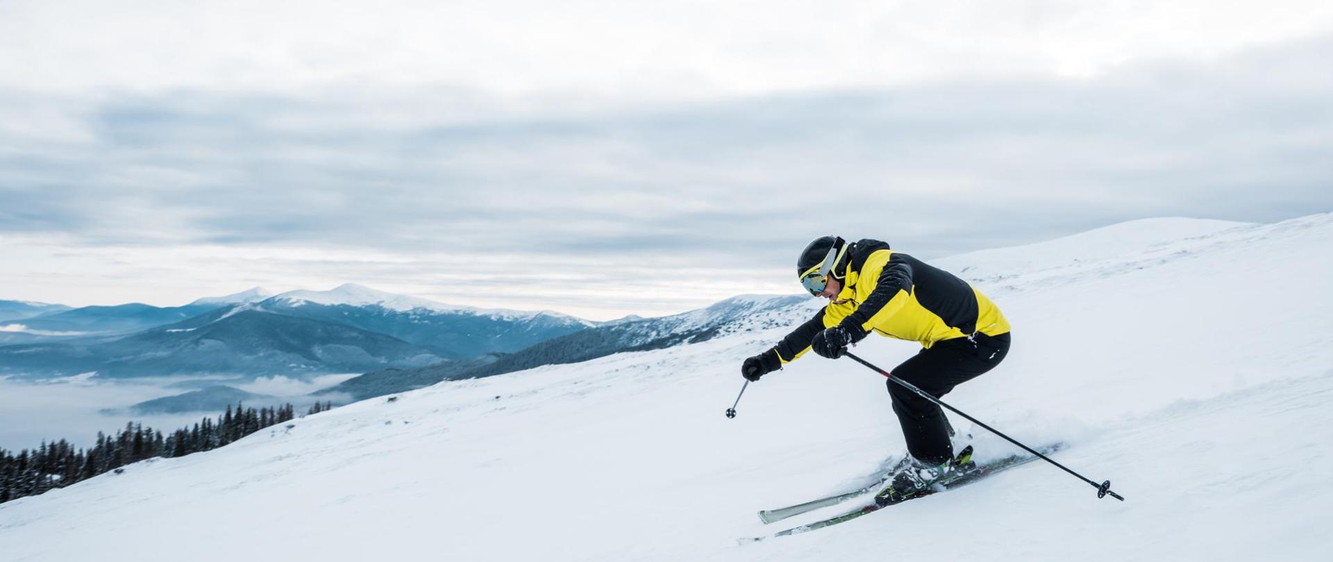 Na zdjęciu jest zjeżdżający narciarz na stoku narciarskim.