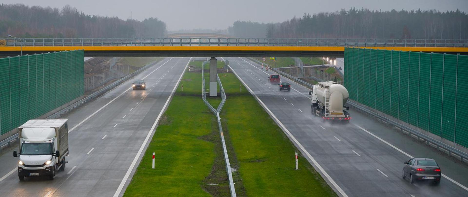 Droga szybkiego ruchu w jesiennej aurze, widoczność ograniczona przez pochmurną pogodę, trasa mokra po opadach deszczu