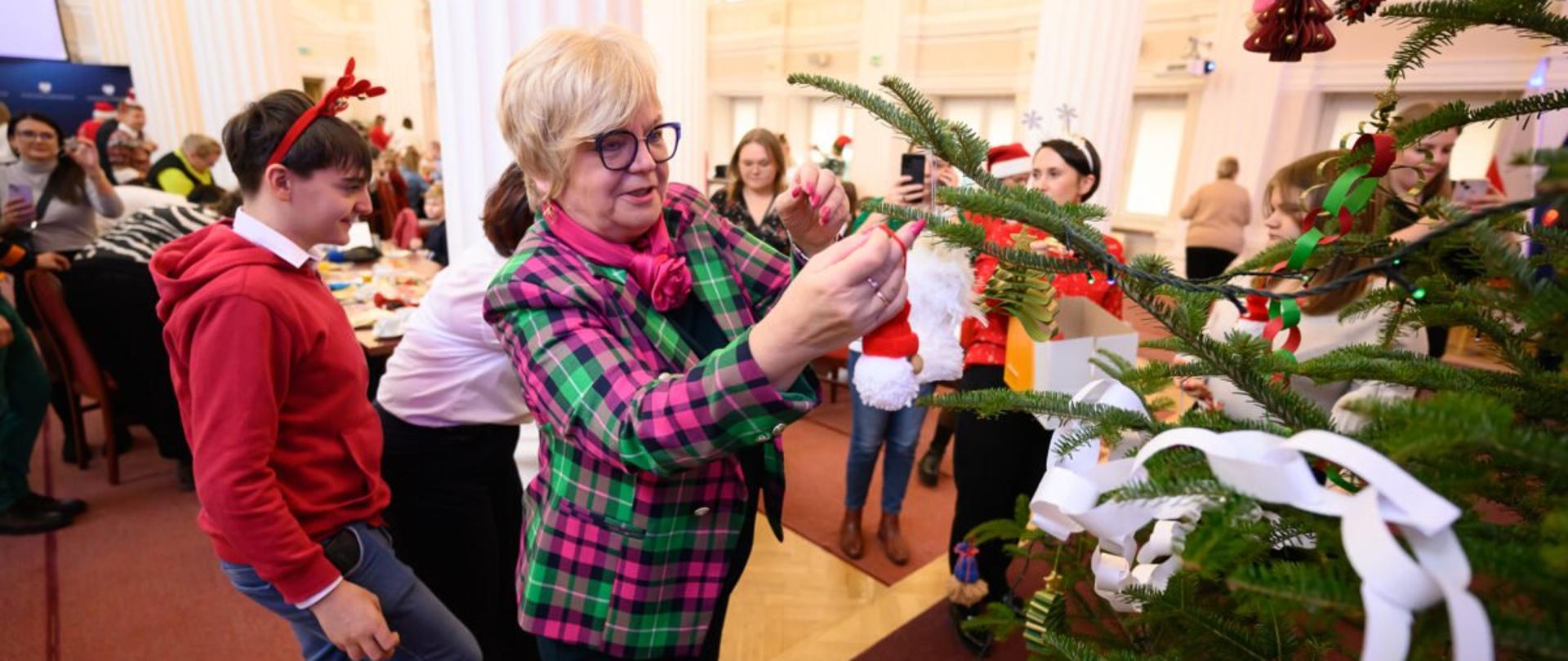 Wojewoda podkarpacki Teresa Kubas-Hul ubierająca choinkę razem z dziećmi z domów dziecka