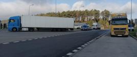 Dwa pojazdy ciężarowe podczas kontroli drogowej.