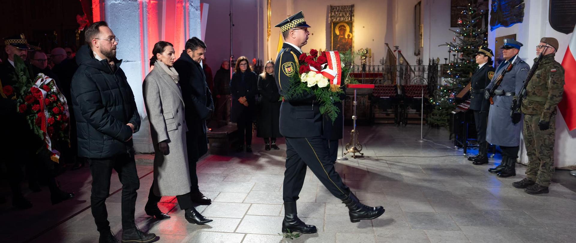 wojewoda w towarzystwie dwóch osób składa wieniec przy grobie Pawła Adamowicza, prezydenta Gdańska