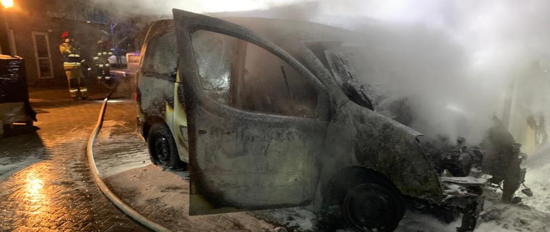 Spalony samochód osobowy na który strażacy podali pianę