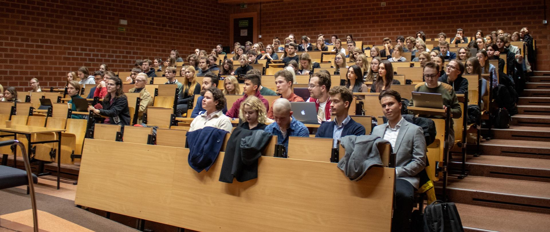 Zdjęcie przedstawia studentów słuchających wykładu