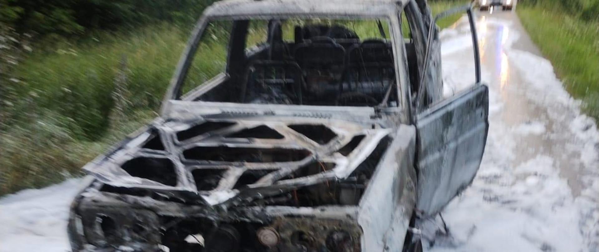 Spalony samochód terenowy pokryty pianą