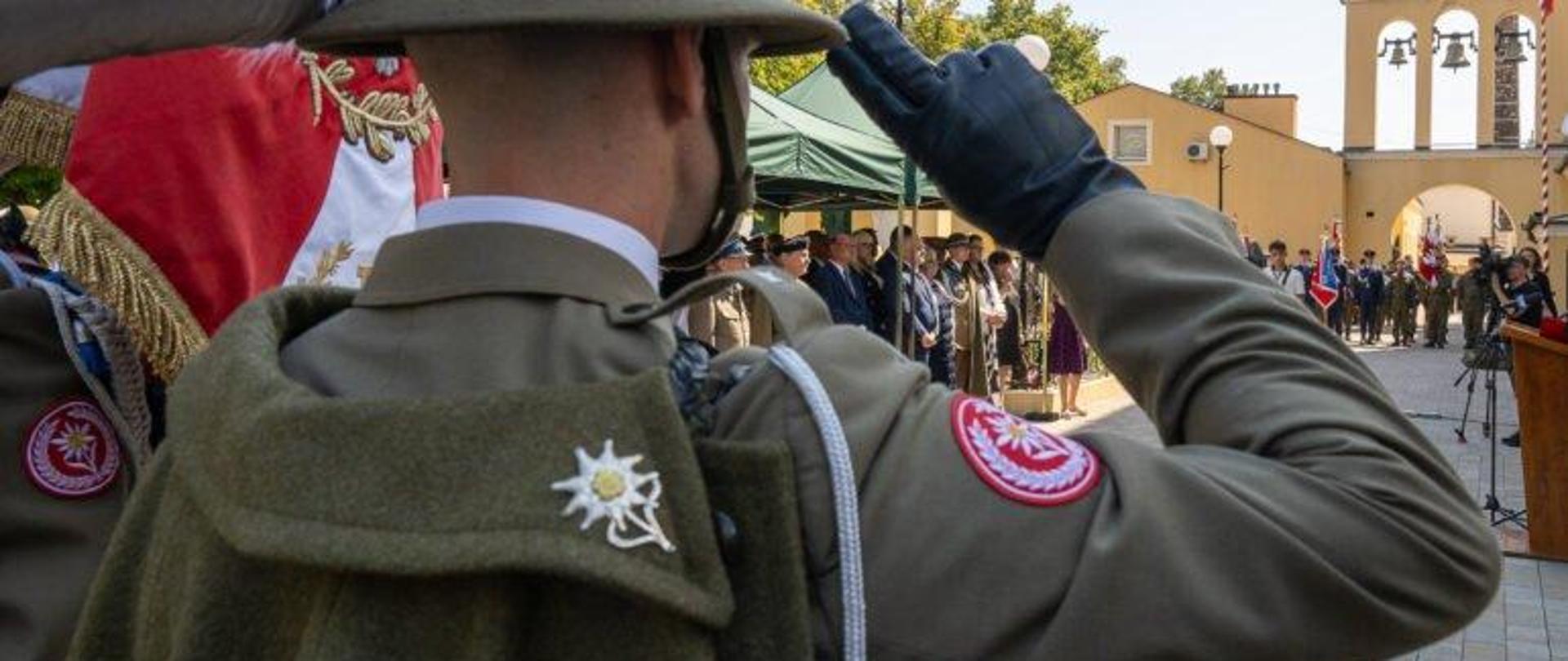 Żołnierz stojący przed uczestnikami uroczystości