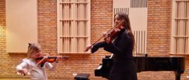 Dziewczynka i nauczycielka grające na skrzypcach