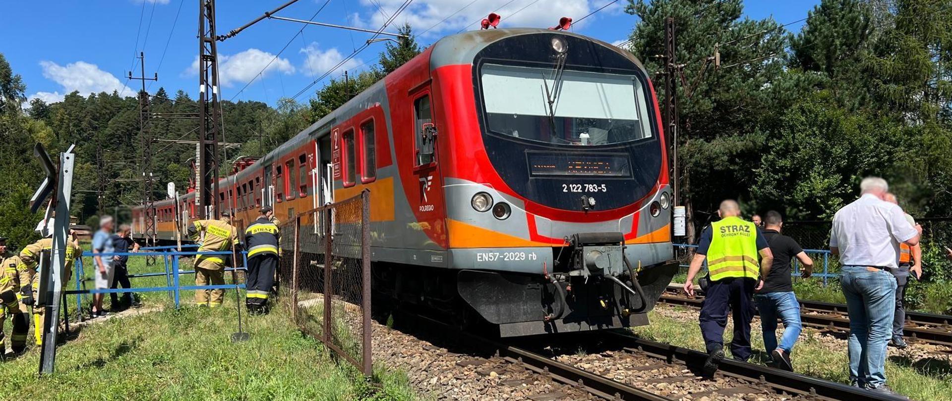 Pociąg a obok strażacy i inne służby