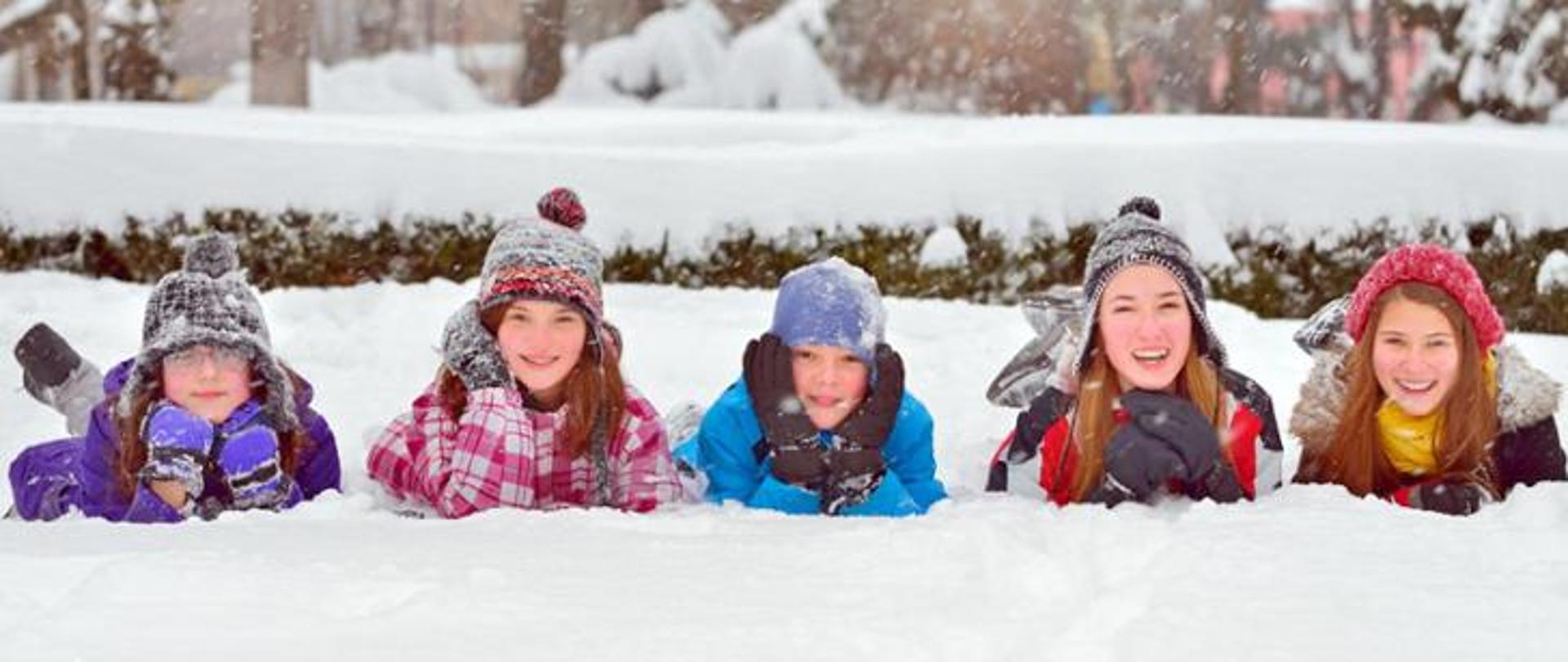 Uśmiechnięte dzieci podczas zabawy na śniegu