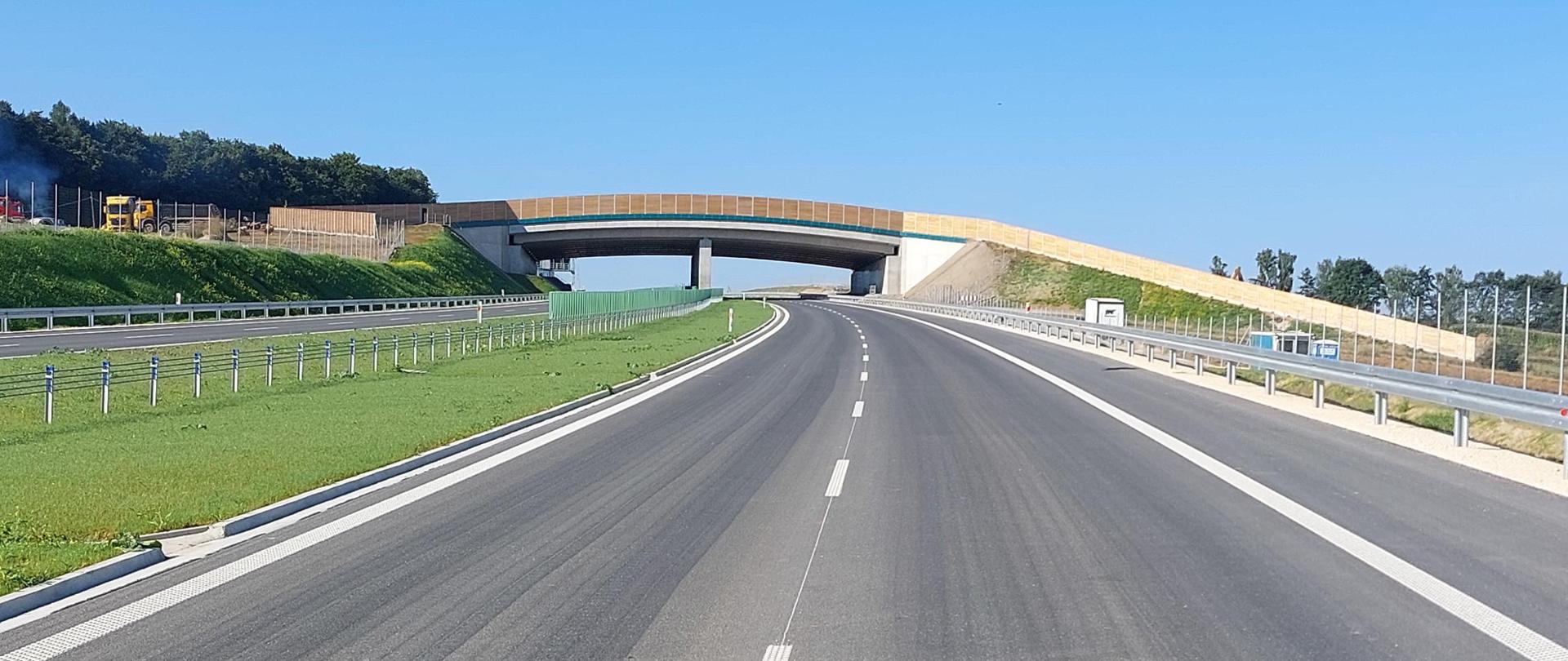 Droga ekspresowa S7 na odcinku Moczydło - Miechów tuż przed udostępnieniem do ruchu. Na zdjęciu dwie jezdnie drogi ekspresowej po dwa pasy ruchu w każdym kierunku. Trwają prace wykończeniowe.