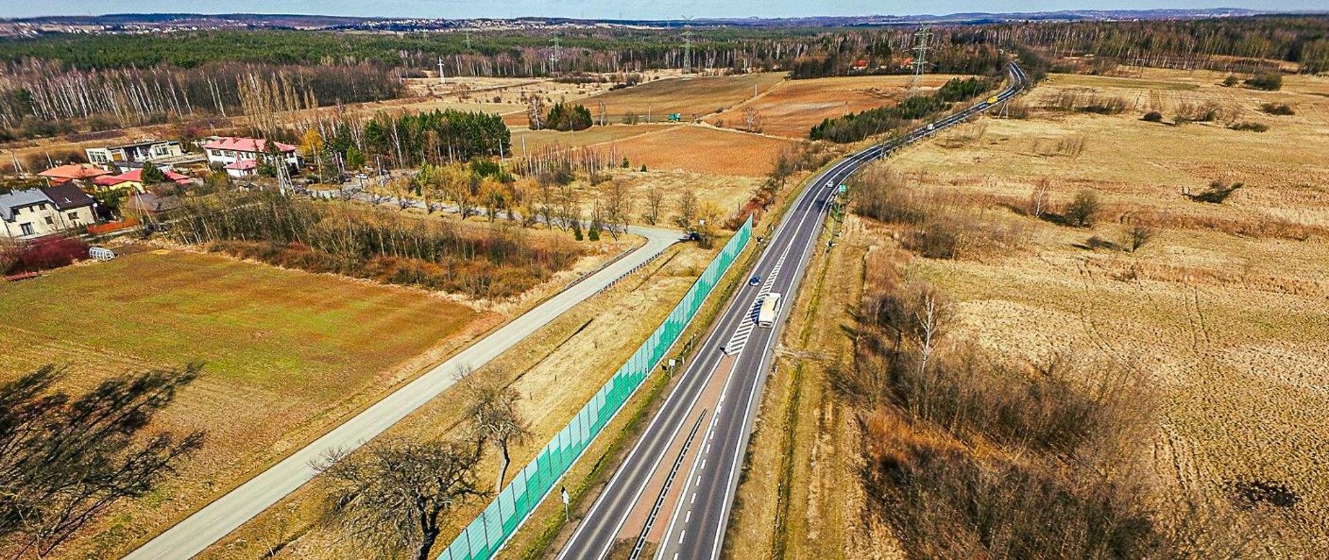 Fotografia z lotu ptaka na istniejącą drogę krajową nr 78. W dolnej części fotografii droga ma przekrój dwujezdniowy, który w środkowej i górnej części zmienia się w przekrój jednojezdniowy. W tym właśnie miejscu zlokalizowany jest początek pierwszego odcinka obwodnicy Poręby i Zawiercia.