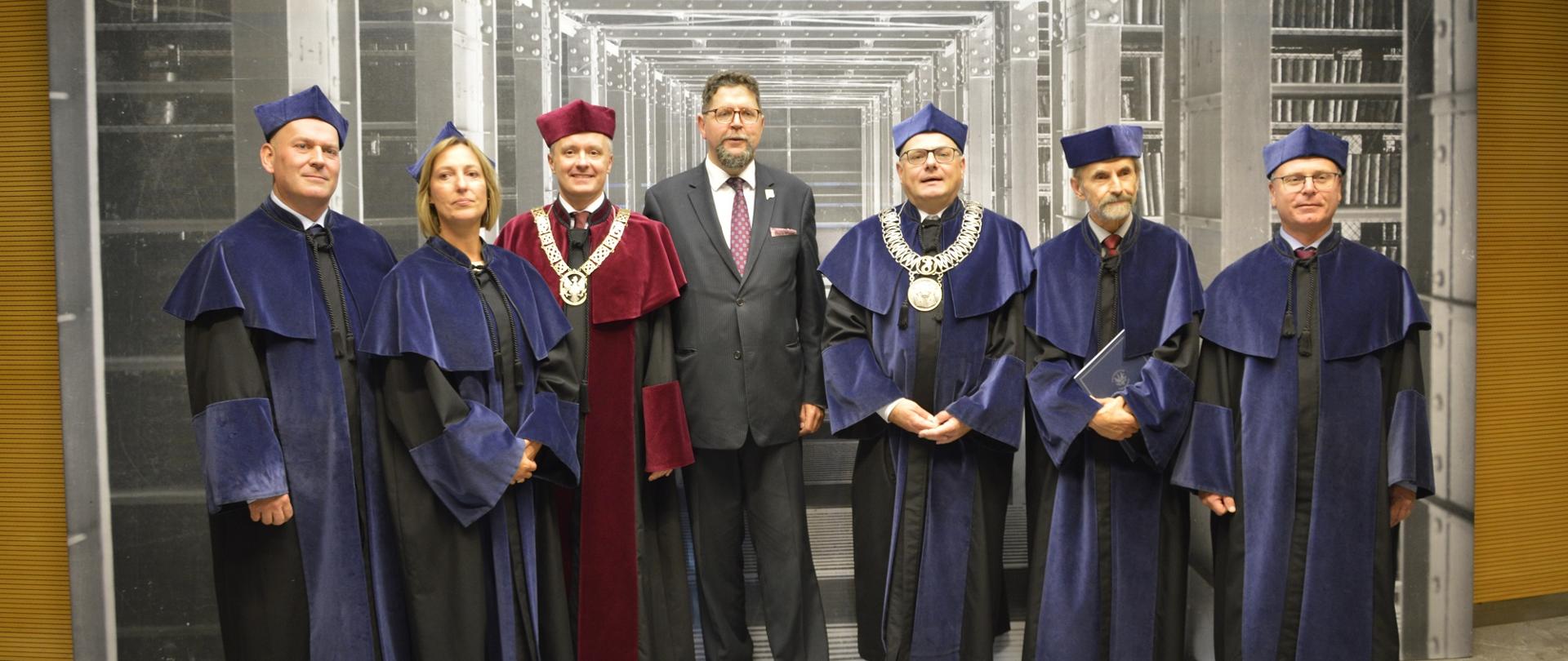 Wiceminister Szeptycki stoi pośrodku grupy osób w ceremonialnych strojach.