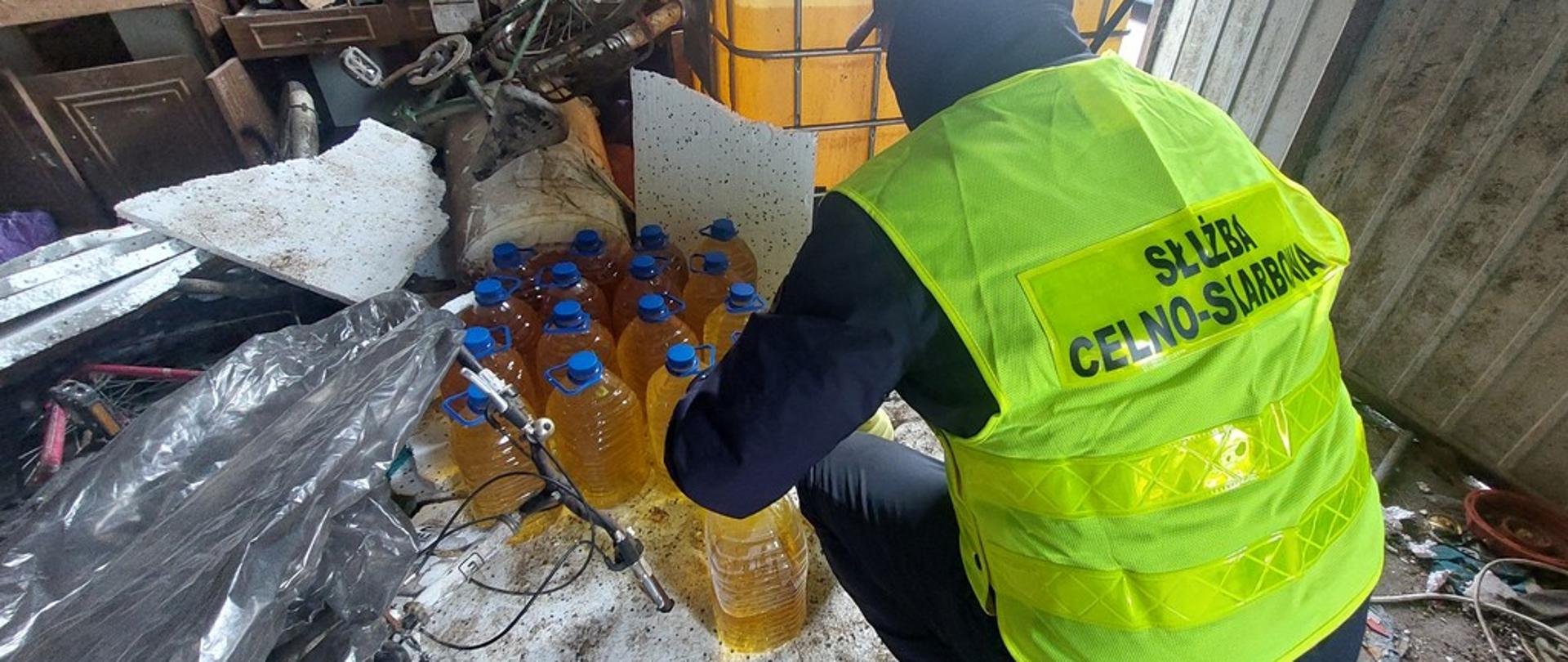 Funkcjonariusz KAS przy butelkach z alkoholem