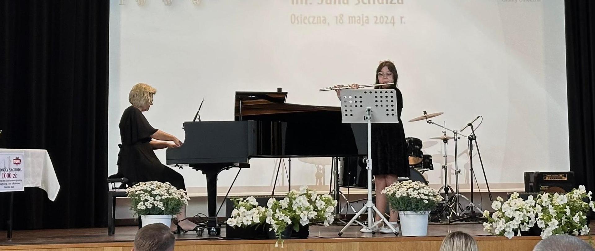 Uczennica Maja Solak grająca na flecie, nauczycielka pani Anna Muszkieta przy fortepianie na scenie podczas występu na konkursie w Osiecznej.